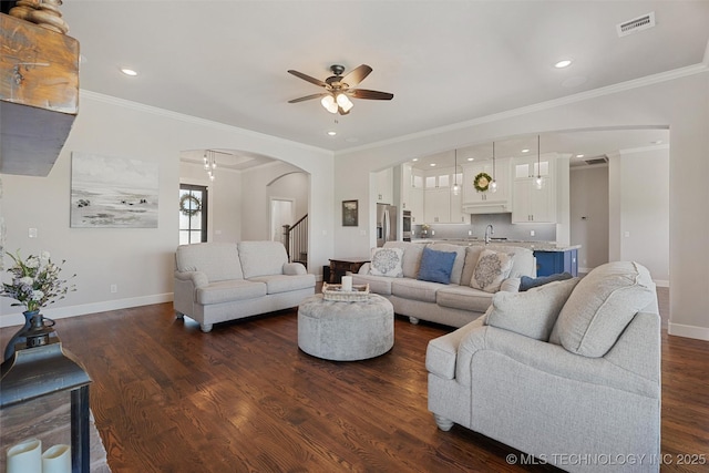 8209 N 150th Ave E, Owasso, OK 74055 - living area featuring arched walkways, a ceiling fan, baseboards, dark wood-style floors, and ornamental molding