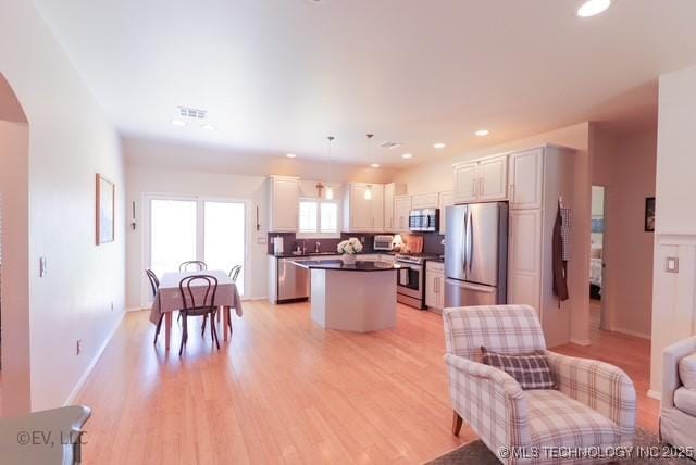 14538 S Kendalwood Blvd E, Glenpool, OK 74033 - kitchen with appliances with stainless steel finishes, a center island, light wood-type flooring, dark countertops, and recessed lighting
