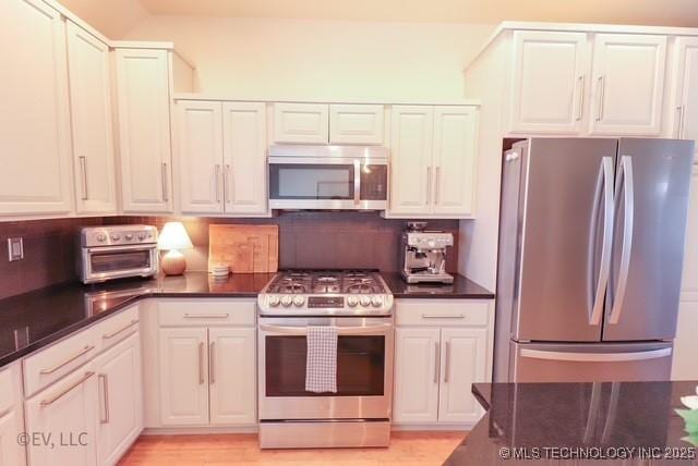 14538 S Kendalwood Blvd E, Glenpool, OK 74033 - kitchen featuring stainless steel appliances, dark countertops, backsplash, and white cabinetry
