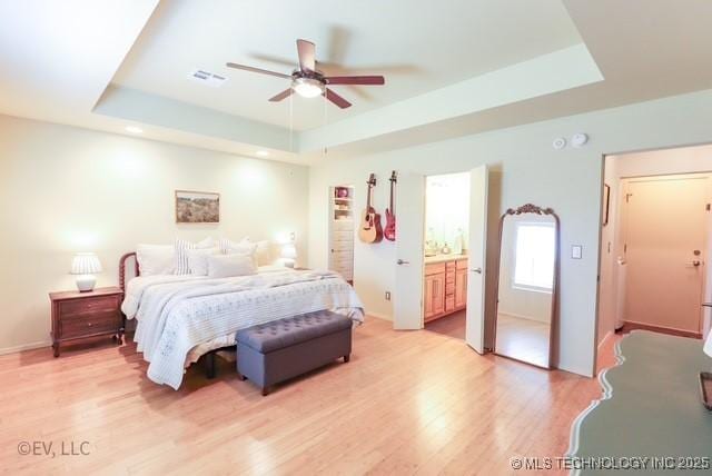 14538 S Kendalwood Blvd E, Glenpool, OK 74033 - bedroom featuring a tray ceiling, light wood finished floors, ensuite bath, and baseboards