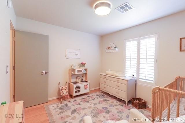 14538 S Kendalwood Blvd E, Glenpool, OK 74033 - bedroom with light wood-style flooring, a crib, and baseboards