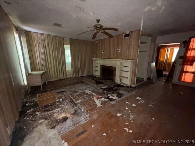 710 F St NW, Ardmore, OK 73401 - unfurnished living room with a ceiling fan, a fireplace, and a textured ceiling