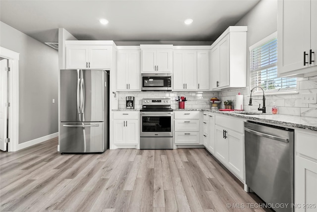 8323 S 2nd W, Muskogee, OK 74401 - kitchen featuring stainless steel appliances, tasteful backsplash, white cabinets, light wood finished floors, and light stone counters