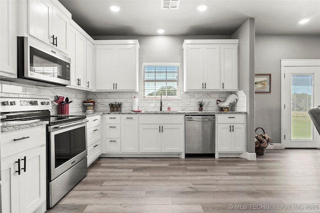 8323 S 2nd W, Muskogee, OK 74401 - kitchen with stainless steel appliances, a sink, recessed lighting, light wood-style flooring, and white cabinetry