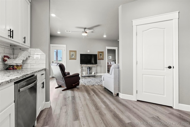 8323 S 2nd W, Muskogee, OK 74401 - kitchen with stainless steel dishwasher, decorative backsplash, light wood-style floors, white cabinets, and a ceiling fan