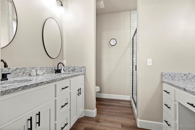 8315 S 2nd W, Muskogee, OK 74401 - bathroom with double vanity, toilet, wood finished floors, and baseboards