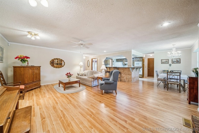 13200 E 130th St S, Broken Arrow, OK 74011 - living room with a textured ceiling, crown molding, light wood-style floors, a ceiling fan, and a chandelier