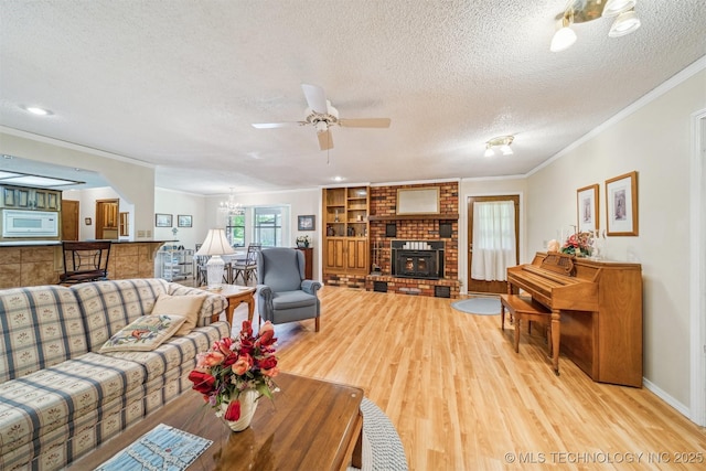 13200 E 130th St S, Broken Arrow, OK 74011 - living room with ornamental molding, light wood-style floors, a textured ceiling, a ceiling fan, and a fireplace