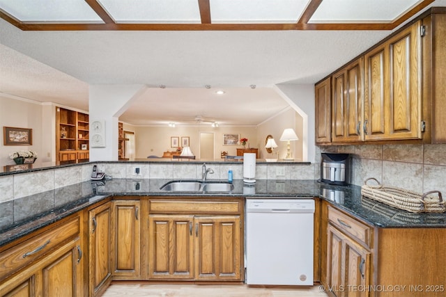 13200 E 130th St S, Broken Arrow, OK 74011 - kitchen with white dishwasher, a sink, brown cabinets, dark stone counters, and backsplash