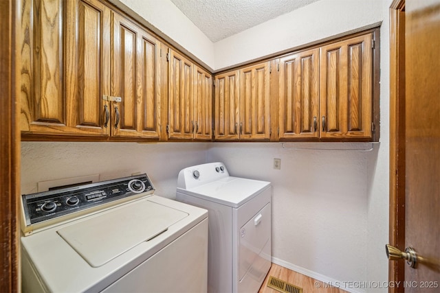 13200 E 130th St S, Broken Arrow, OK 74011 - washroom featuring washer and clothes dryer, a textured ceiling, cabinet space, and baseboards