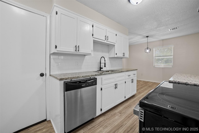 401 E 25th St, Okmulgee, OK 74447 - kitchen with stainless steel dishwasher, a sink, light wood finished floors, backsplash, and white cabinets