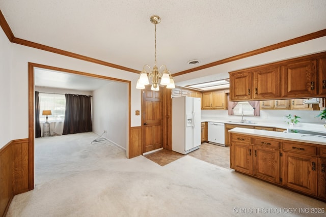 10925 E 4th St, Tulsa, OK 74128 - kitchen featuring white appliances, a sink, light countertops, wainscoting, and a chandelier