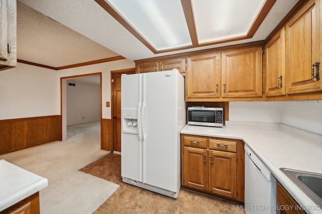10925 E 4th St, Tulsa, OK 74128 - kitchen with white appliances, light countertops, brown cabinets, wainscoting, and tasteful backsplash