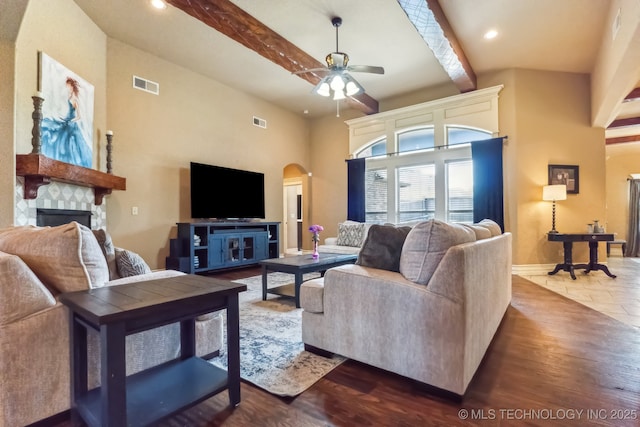 9512 N 144th E Ave, Owasso, OK 74055 - living room with arched walkways, a ceiling fan, beamed ceiling, a stone fireplace, and baseboards
