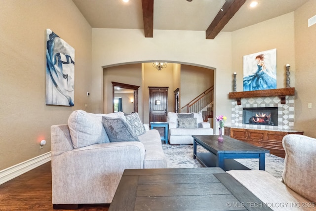 9512 N 144th E Ave, Owasso, OK 74055 - living area with arched walkways, beamed ceiling, wood finished floors, a fireplace, and baseboards