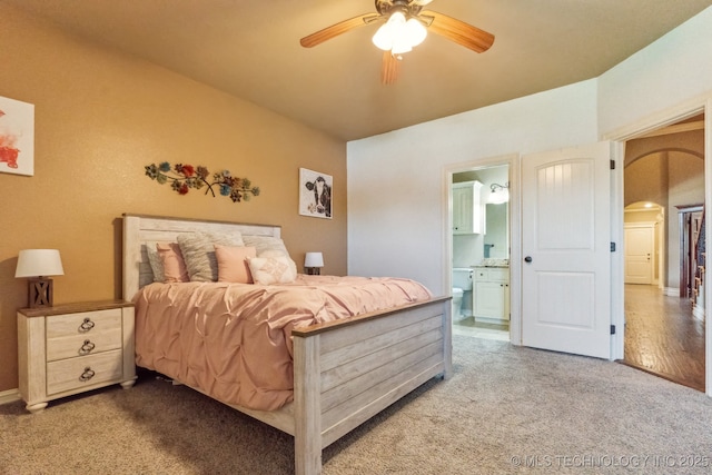 9512 N 144th E Ave, Owasso, OK 74055 - carpeted bedroom with arched walkways, ensuite bathroom, ceiling fan, and vaulted ceiling