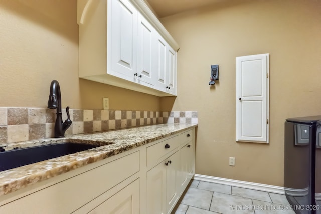 9512 N 144th E Ave, Owasso, OK 74055 - kitchen with a sink, white cabinets, light tile patterned floors, light stone counters, and baseboards