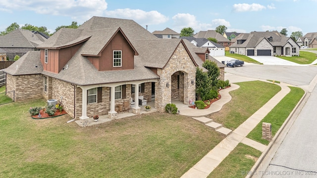 9512 N 144th E Ave, Owasso, OK 74055 - french country style house featuring stone siding, roof with shingles, a residential view, covered porch, and concrete driveway