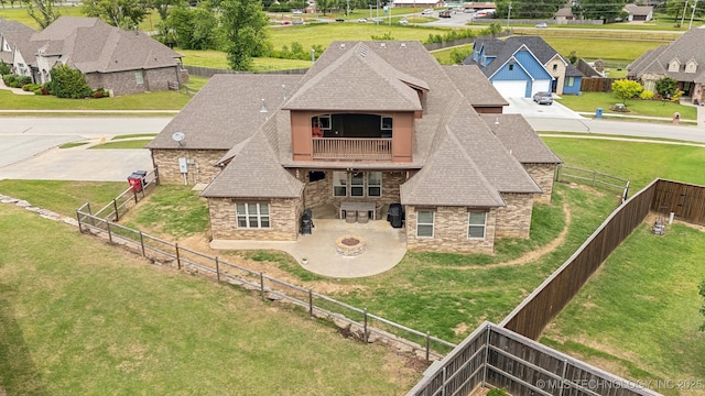 9512 N 144th E Ave, Owasso, OK 74055 - rear view of house with stone siding, roof with shingles, a balcony, a patio area, and a residential view
