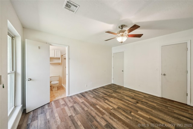 8208 N 122nd E Ave, Owasso, OK 74055 - unfurnished bedroom featuring wood finished floors, ensuite bathroom, and ceiling fan