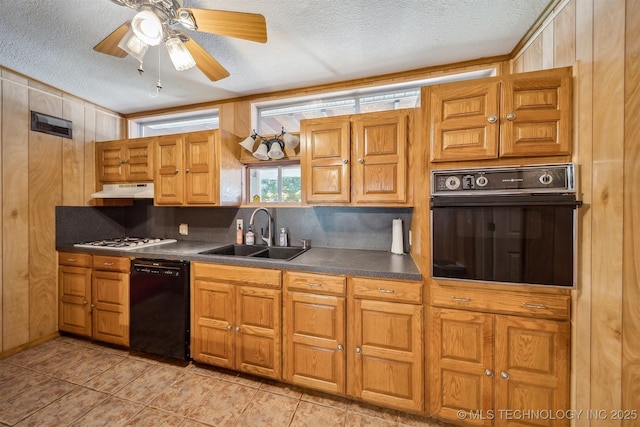4921 E 26th St, Tulsa, OK 74114 - kitchen featuring black appliances, a sink, a textured ceiling, under cabinet range hood, and dark countertops