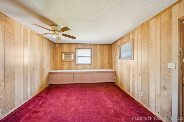 4921 E 26th St, Tulsa, OK 74114 - carpeted spare room with wood walls, ceiling fan, a textured ceiling, and a wall mounted AC