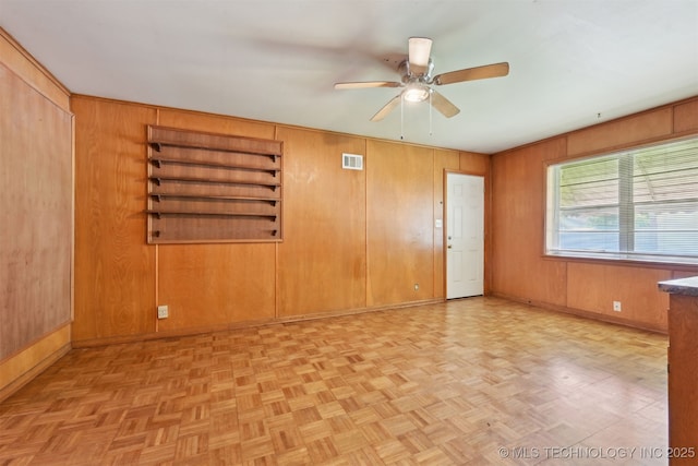 1604 E 55th Pl, Tulsa, OK 74105 - unfurnished room featuring a ceiling fan, wooden walls, and baseboards