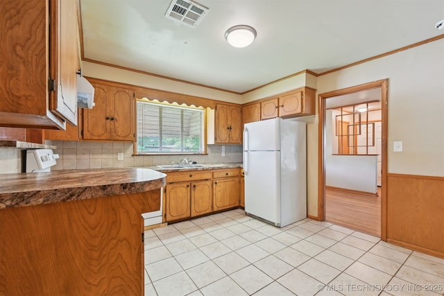 1604 E 55th Pl, Tulsa, OK 74105 - kitchen with freestanding refrigerator, exhaust hood, a sink, brown cabinetry, and ornamental molding