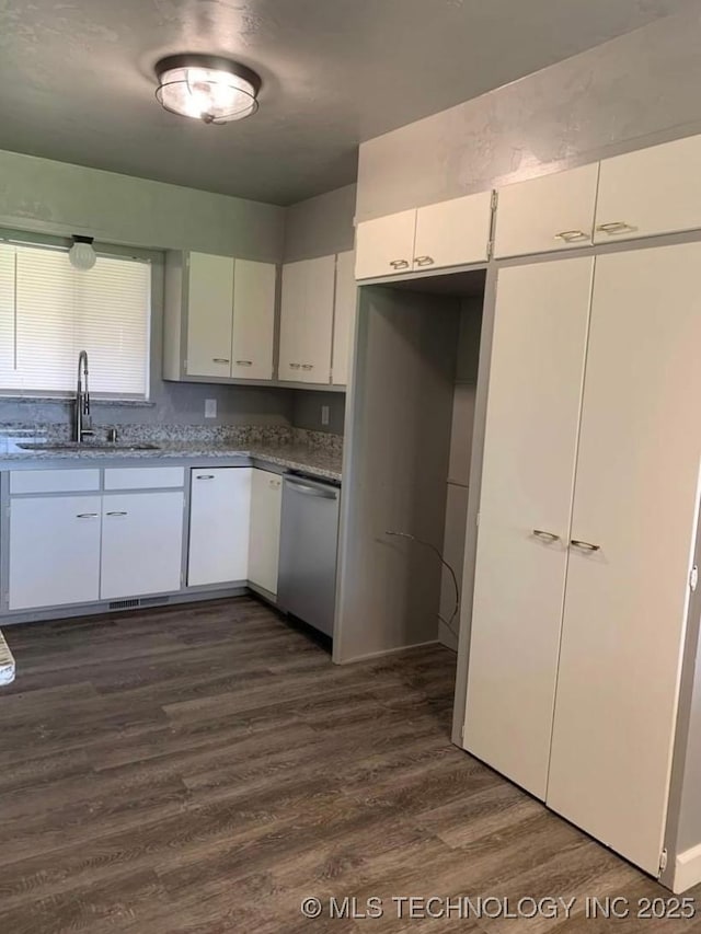 1011 E 11th St, Cushing, OK 74023 - kitchen with dishwasher, a sink, dark wood-style floors, white cabinetry, and light stone counters