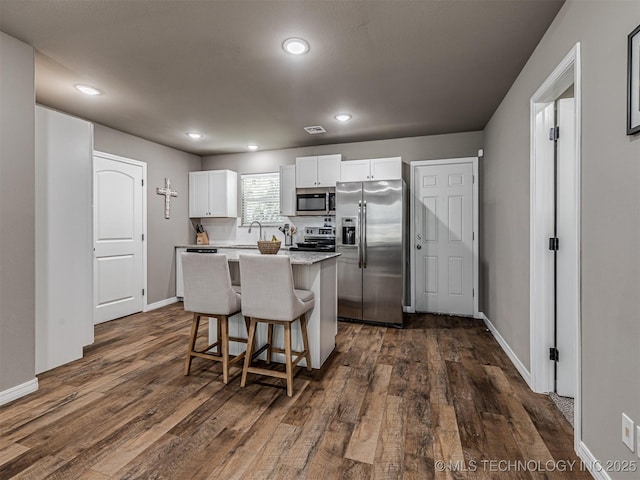 228 W Ohio Ave, Kiefer, OK 74041 - kitchen with stainless steel appliances, a center island, dark wood-style floors, white cabinetry, and recessed lighting