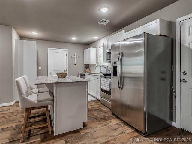228 W Ohio Ave, Kiefer, OK 74041 - kitchen featuring stainless steel appliances, a kitchen island, white cabinets, light stone countertops, and dark wood-style floors