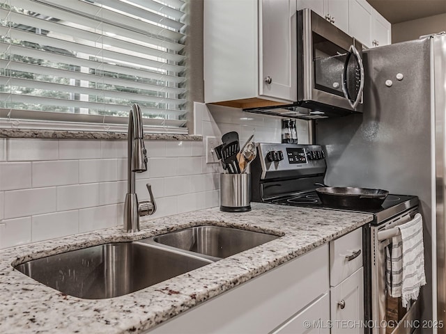 228 W Ohio Ave, Kiefer, OK 74041 - kitchen with stainless steel appliances, a sink, tasteful backsplash, white cabinetry, and light stone counters