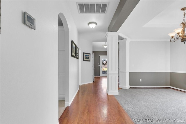 3000 S Tamarack Ave, Broken Arrow, OK 74012 - hallway with wood finished floors, a chandelier, baseboards, arched walkways, and ornate columns