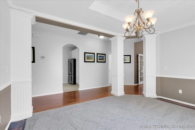 3000 S Tamarack Ave, Broken Arrow, OK 74012 - unfurnished room with carpet, arched walkways, a chandelier, decorative columns, and wood finished floors