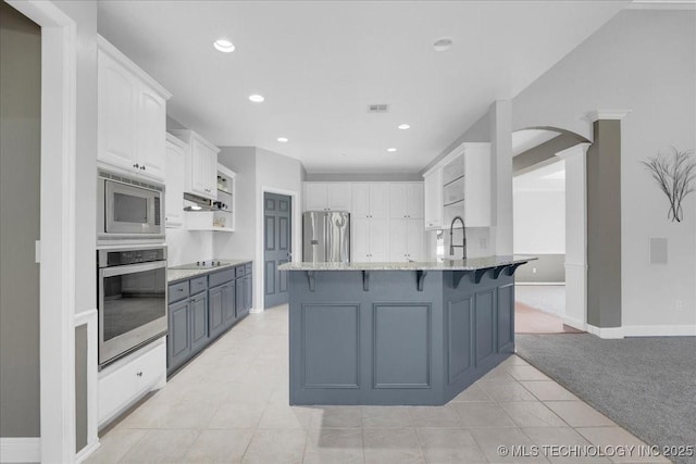 3000 S Tamarack Ave, Broken Arrow, OK 74012 - kitchen with stainless steel appliances, a peninsula, light colored carpet, white cabinets, and light tile patterned flooring