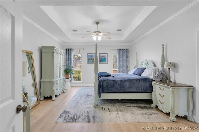 3000 S Tamarack Ave, Broken Arrow, OK 74012 - bedroom with a tray ceiling, light wood-type flooring, crown molding, and a ceiling fan