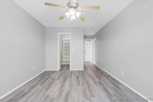 3000 S Tamarack Ave, Broken Arrow, OK 74012 - unfurnished bedroom with wood finished floors, a walk in closet, baseboards, a closet, and ceiling fan