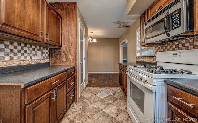 506 W 17th, Sulphur, OK 73086 - kitchen featuring white gas stove, stainless steel microwave, and dark countertops