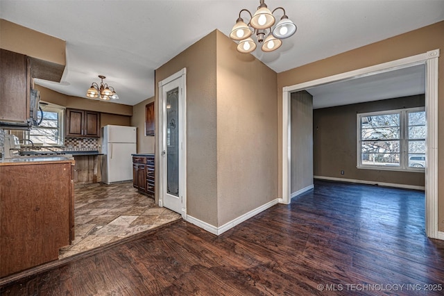 506 W 17th, Sulphur, OK 73086 - kitchen with a chandelier, freestanding refrigerator, baseboards, wood finished floors, and tasteful backsplash