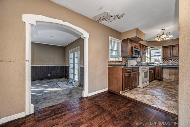 506 W 17th, Sulphur, OK 73086 - kitchen with gas range, stainless steel microwave, dark countertops, and plenty of natural light