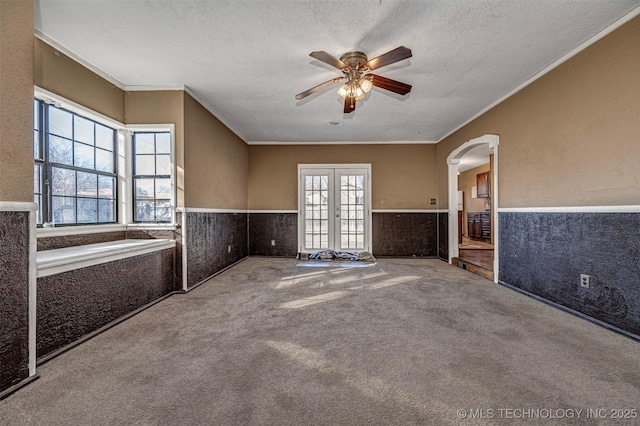 506 W 17th, Sulphur, OK 73086 - spare room featuring wainscoting, ceiling fan, carpet flooring, arched walkways, and a textured ceiling