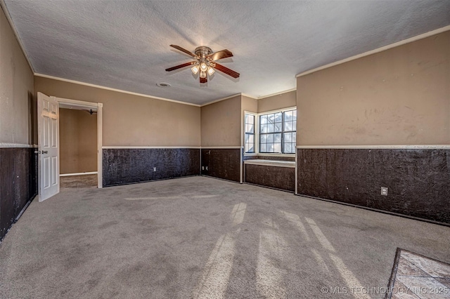 506 W 17th, Sulphur, OK 73086 - unfurnished room featuring a ceiling fan, a wainscoted wall, a textured ceiling, carpet flooring, and crown molding