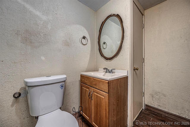 506 W 17th, Sulphur, OK 73086 - half bath with wood finished floors, vanity, toilet, and a textured wall