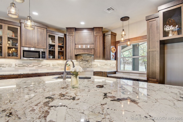 4748 N 4318th Rd, Pryor, OK 74361 - kitchen featuring stainless steel microwave, a sink, tasteful backsplash, light stone countertops, and recessed lighting