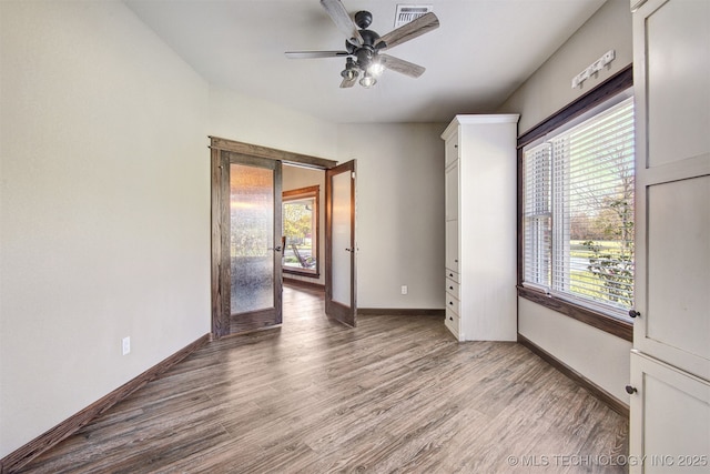 4748 N 4318th Rd, Pryor, OK 74361 - empty room with wood finished floors, ceiling fan, baseboards, and french doors