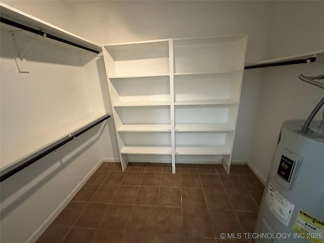 905 Brookside Dr, Durant, OK 74701 - walk in closet featuring water heater and dark tile patterned flooring