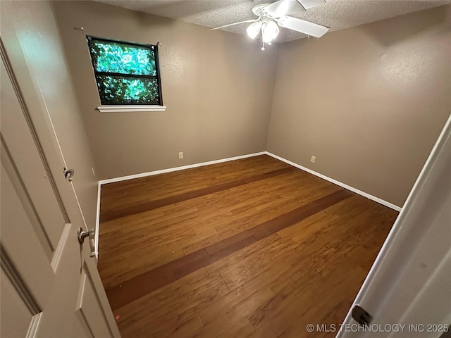 905 Brookside Dr, Durant, OK 74701 - spare room with dark wood-type flooring, ceiling fan, a textured ceiling, and baseboards