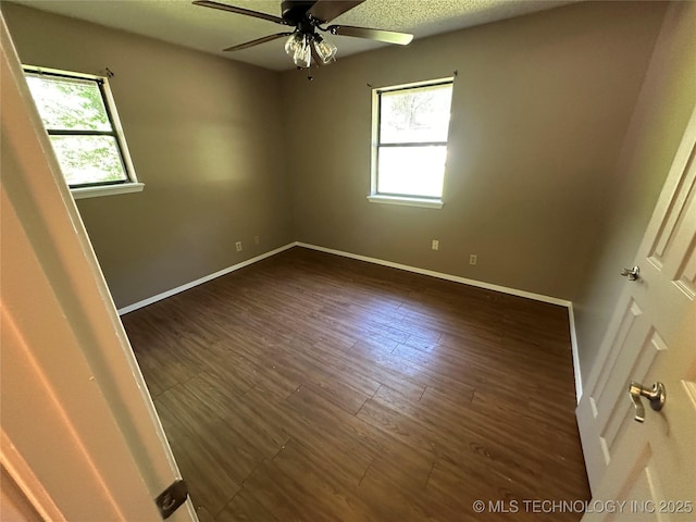 905 Brookside Dr, Durant, OK 74701 - spare room with plenty of natural light, a ceiling fan, baseboards, and dark wood-style flooring