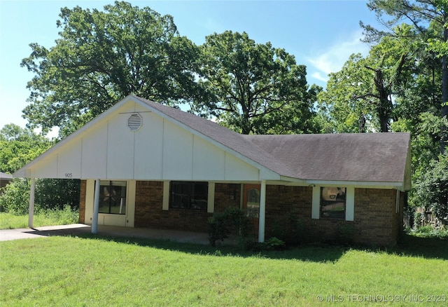905 Brookside Dr, Durant, OK 74701 - view of front of house featuring brick siding, a front lawn, a shingled roof, and an attached carport