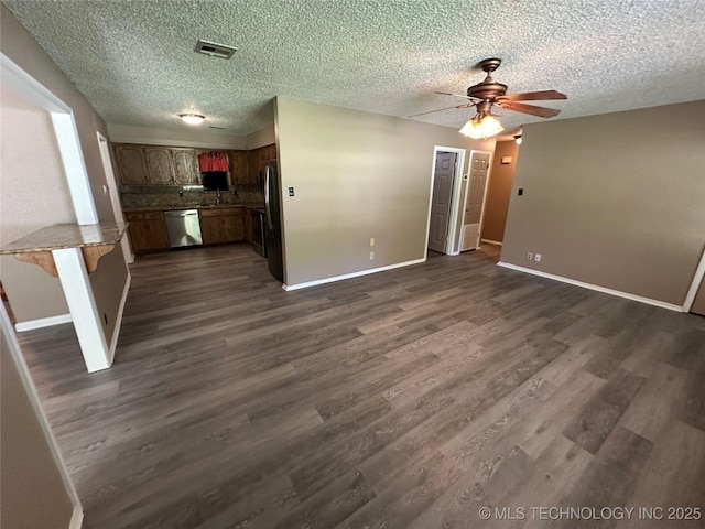 905 Brookside Dr, Durant, OK 74701 - unfurnished living room with a ceiling fan, dark wood-type flooring, baseboards, a textured ceiling, and a sink